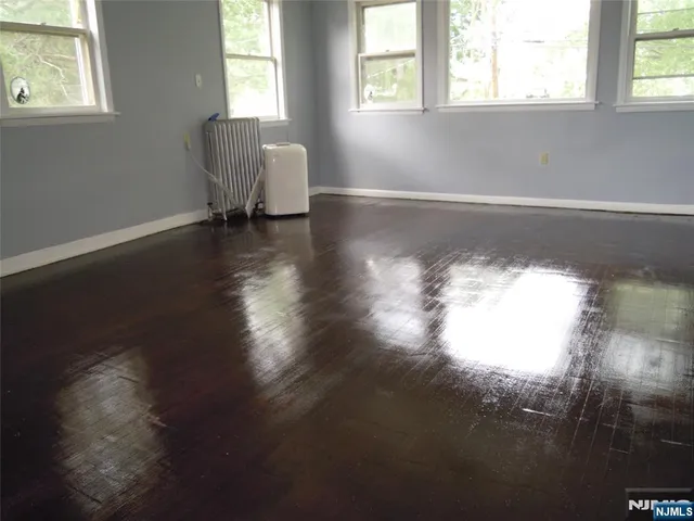 a view of a room with wooden floor and a window