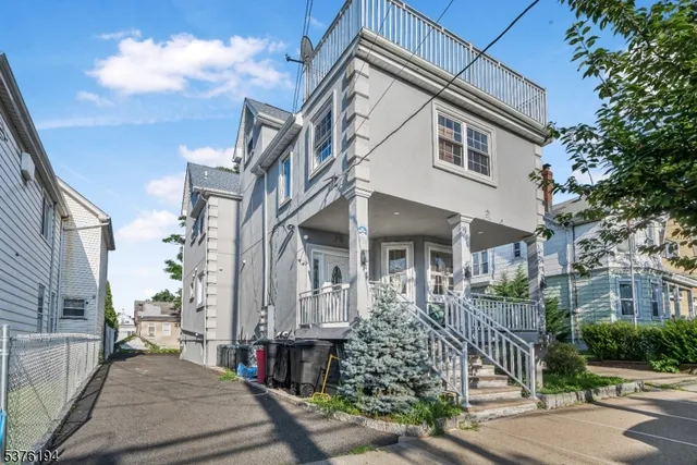 a view of a white building among the street with palm trees