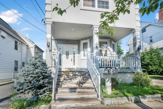 a view of a house with entrance stairs and potted plants