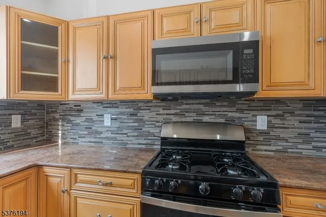 a kitchen with granite countertop a stove top oven cabinetry