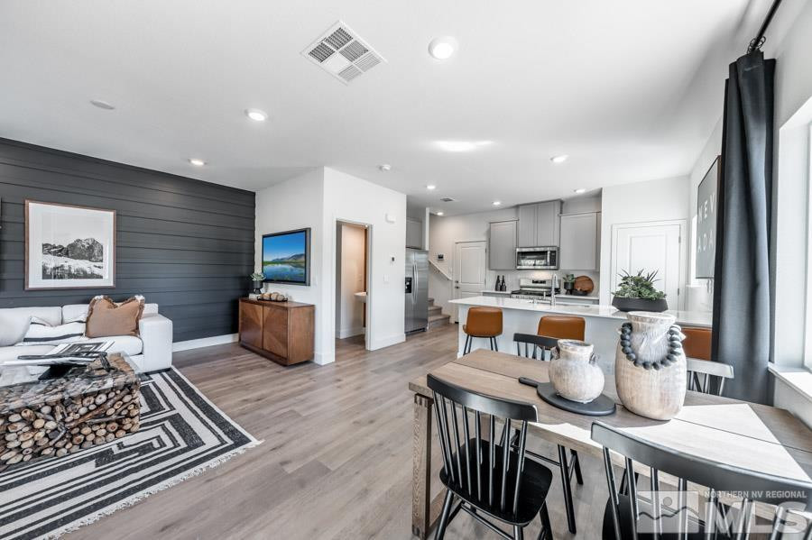 1621 Switchback Street, Unit LOT #25 Reno, NV 89523 - Photo 3 of 19 a kitchen with stainless steel appliances granite countertop a stove top oven a refrigerator a sink and white cabinets with wooden floor