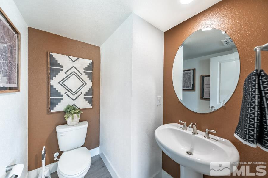 1621 Switchback Street, Unit LOT #25 Reno, NV 89523 - Photo 9 of 19 a bathroom with a toilet sink and mirror