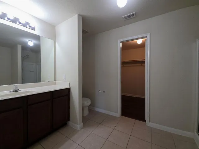 a bathroom with a sink a toilet and large mirror