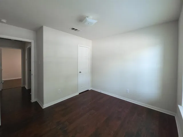 an empty room with wooden floor and closet