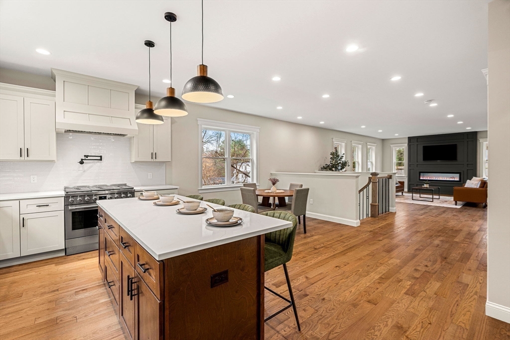 40 Boston Road Andover, MA 01810 - Photo 5 of 42 a kitchen with a stove a sink a kitchen island with chairs and wooden floor
