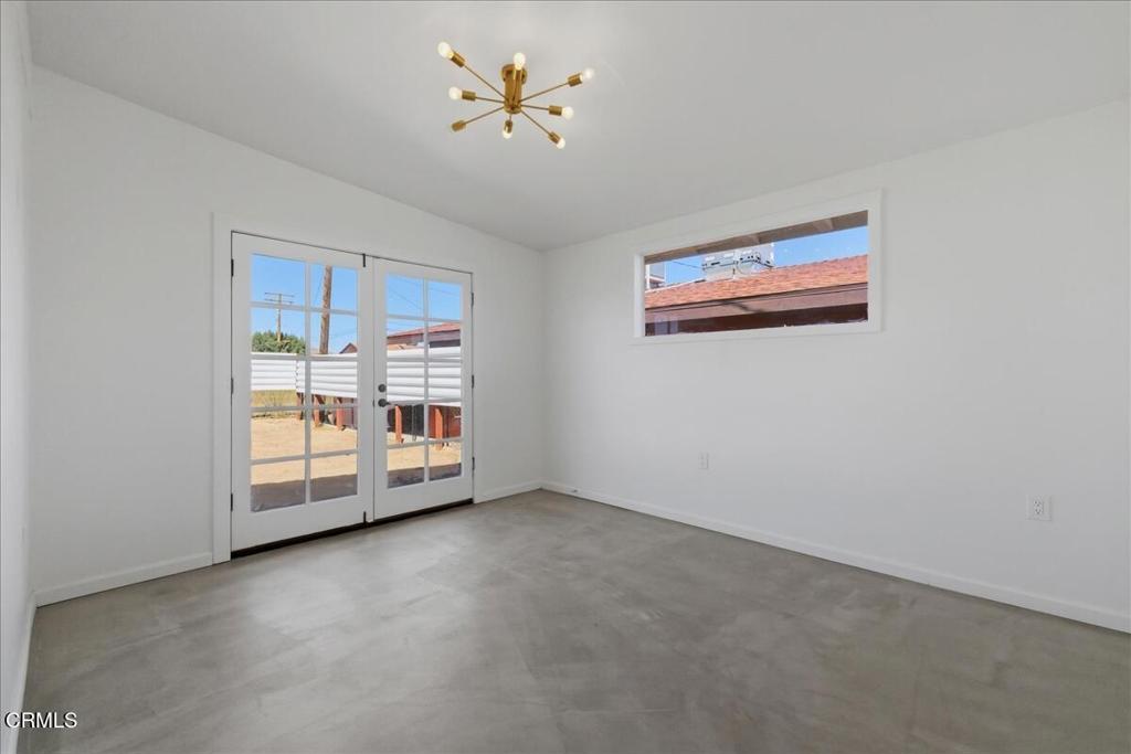 61714 Commercial Street Joshua Tree, CA 92252 - Photo 16 of 42 an empty room with chandelier fan and fire place