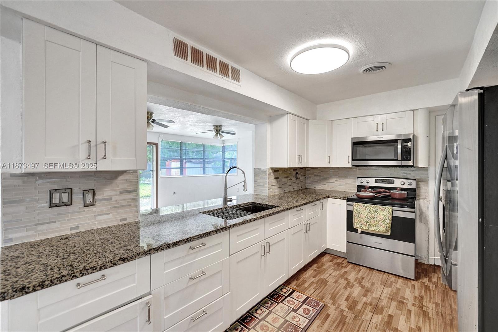 3330 Taft Street Hollywood, FL 33021 - Photo 1 of 70 a kitchen with granite countertop a sink stainless steel appliances and cabinets