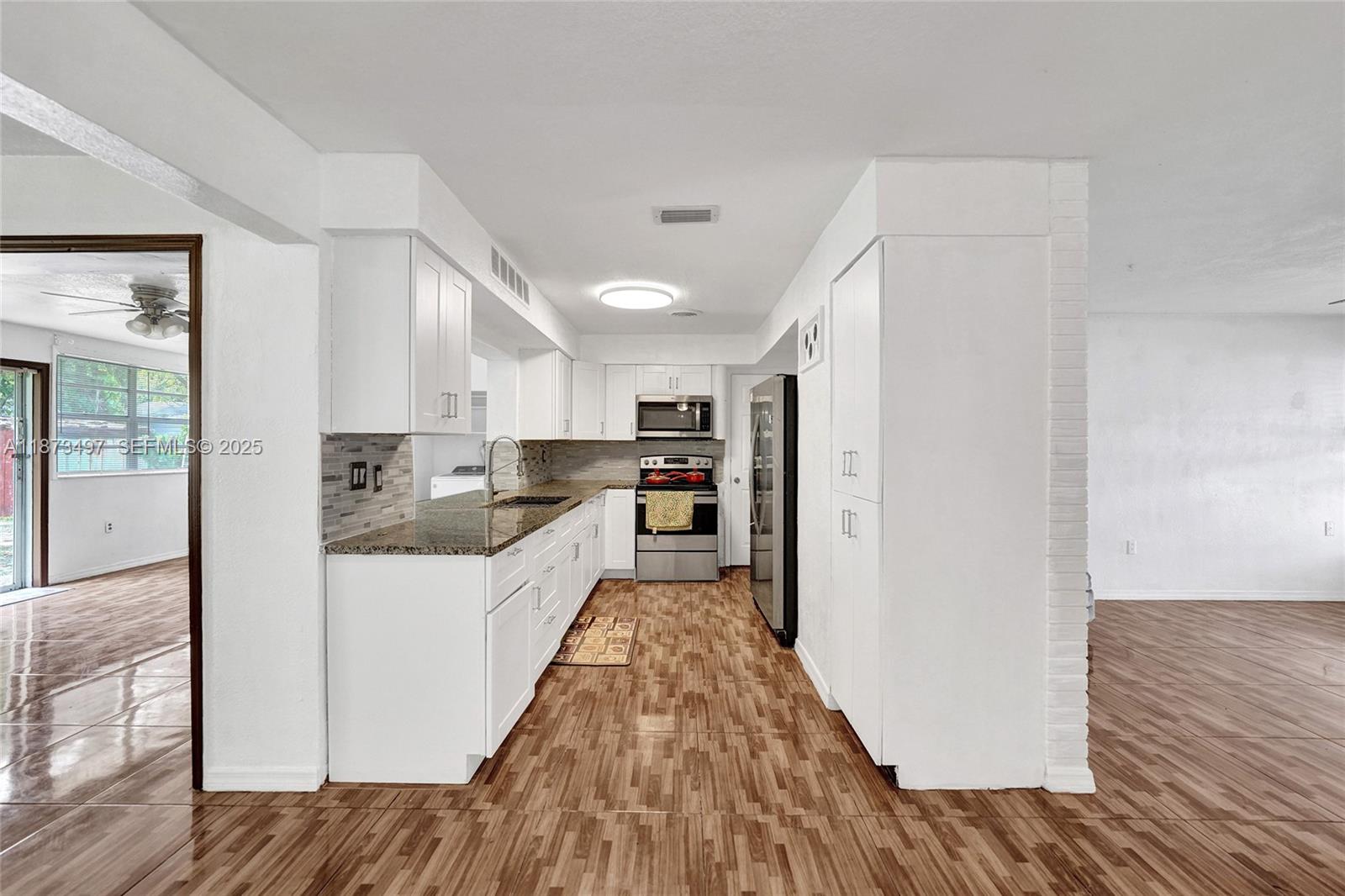 3330 Taft Street Hollywood, FL 33021 - Photo 25 of 70 a large kitchen with a lot of counter space and wooden floor