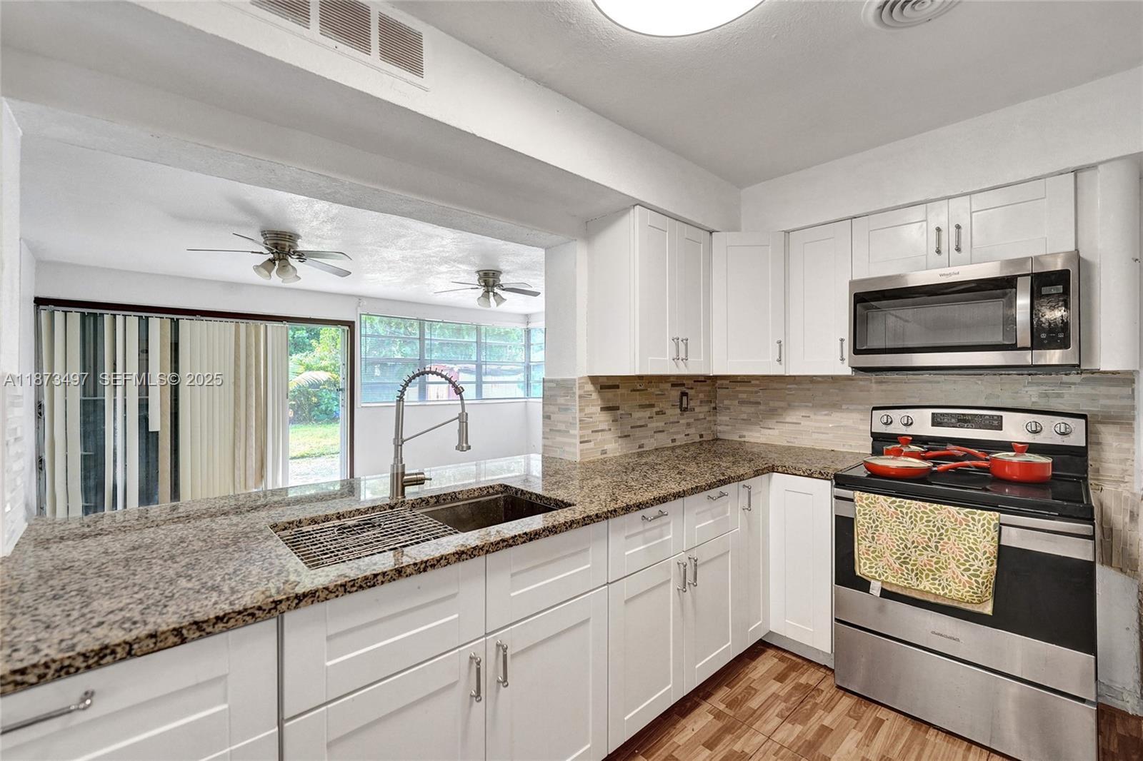 3330 Taft Street Hollywood, FL 33021 - Photo 27 of 70 a kitchen with stainless steel appliances granite countertop a stove a sink and a microwave