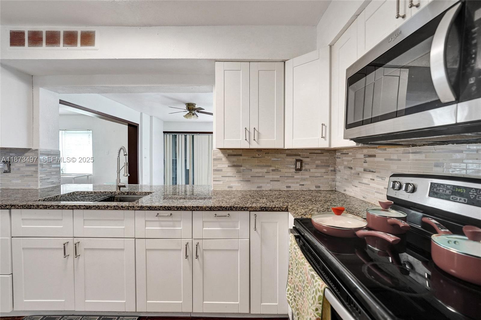 3330 Taft Street Hollywood, FL 33021 - Photo 28 of 70 a kitchen with granite countertop a stove sink and cabinets