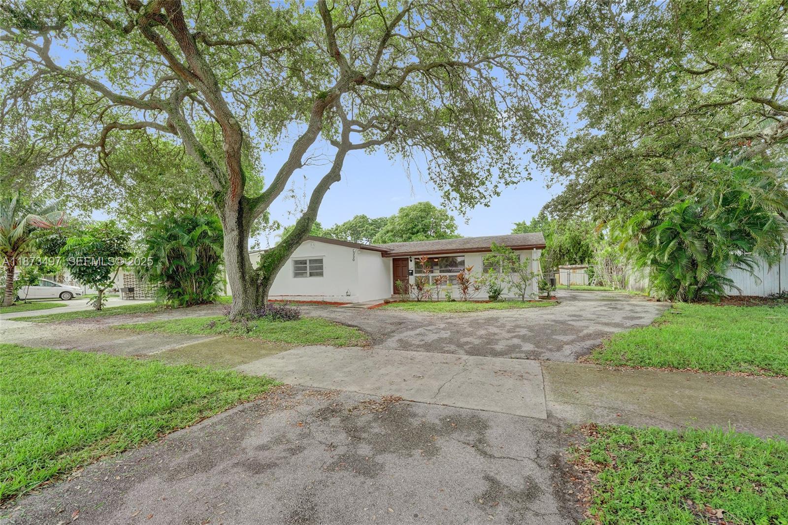 3330 Taft Street Hollywood, FL 33021 - Photo 3 of 70 a view of a house with a yard and large trees