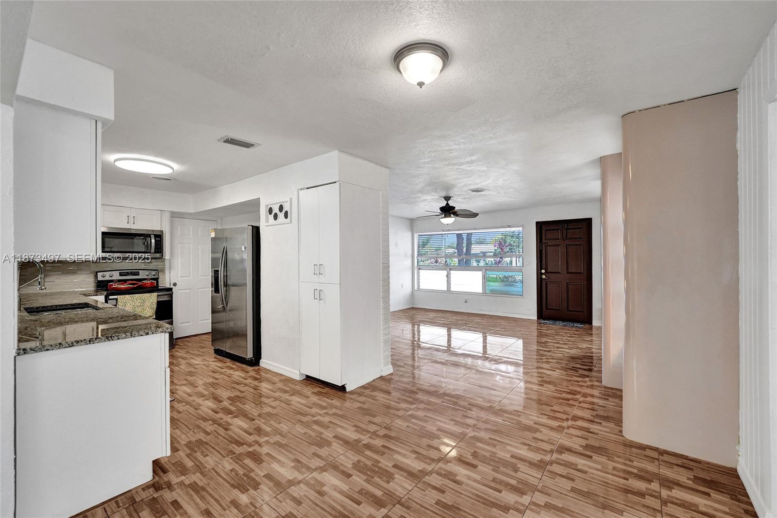3330 Taft Street Hollywood, FL 33021 - Photo 31 of 70 a large kitchen with stainless steel appliances granite countertop a refrigerator and a stove top oven