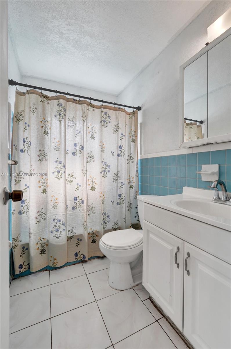 3330 Taft Street Hollywood, FL 33021 - Photo 45 of 70 a bathroom with a granite countertop sink a toilet and a shower