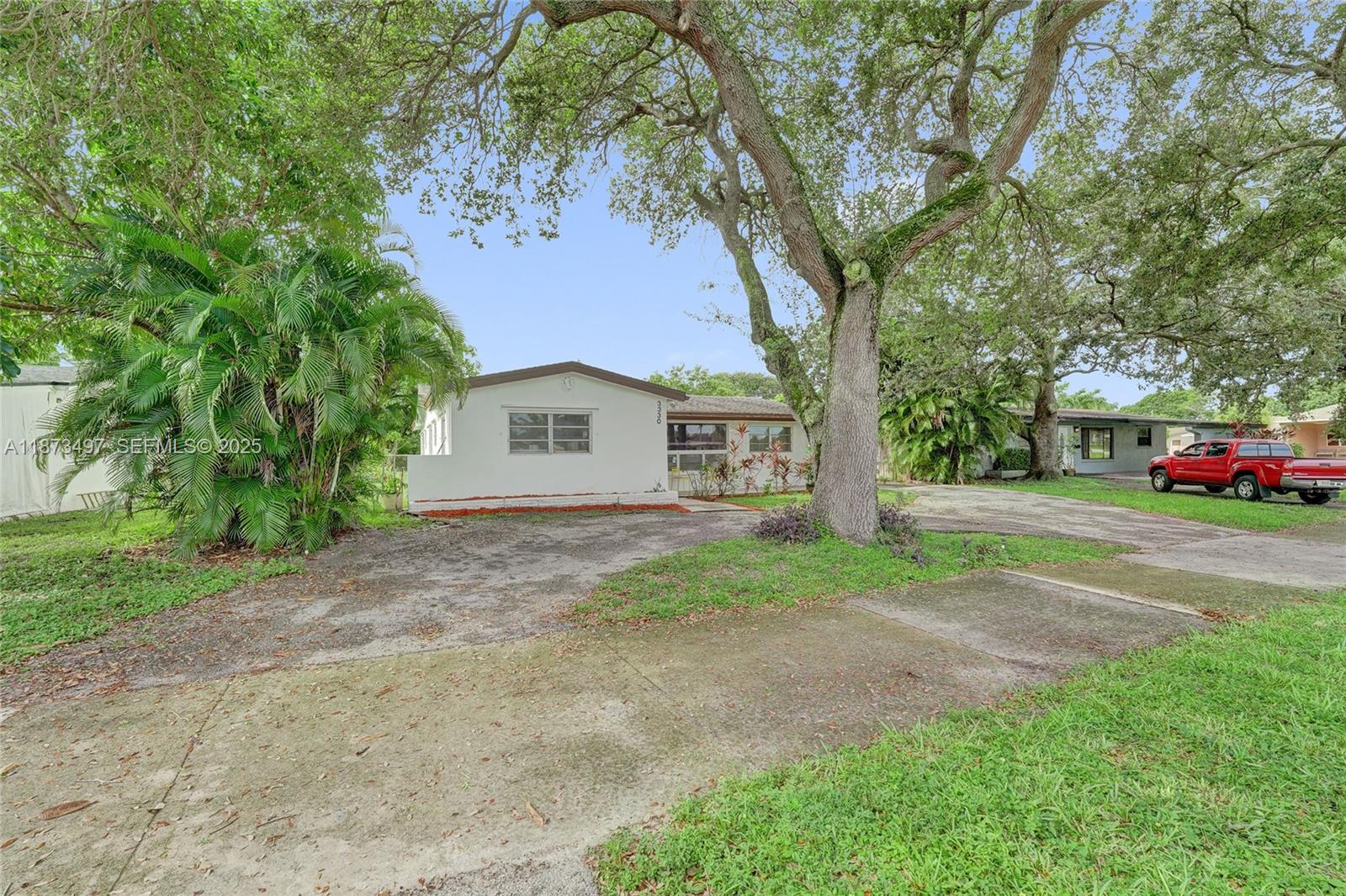 3330 Taft Street Hollywood, FL 33021 - Photo 7 of 70 a tall tree in middle of the garden