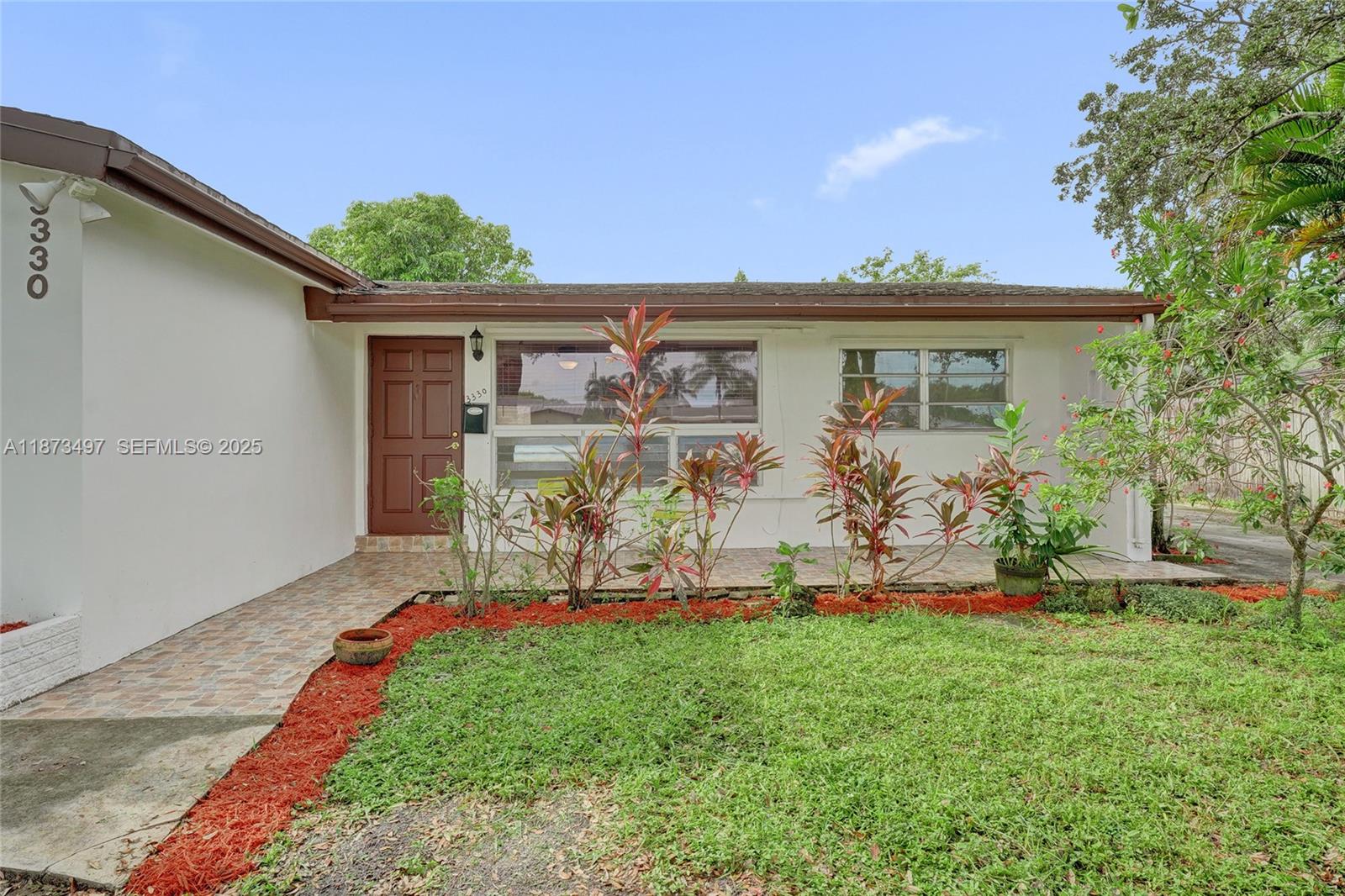 3330 Taft Street Hollywood, FL 33021 - Photo 10 of 70 a front view of a house with garden