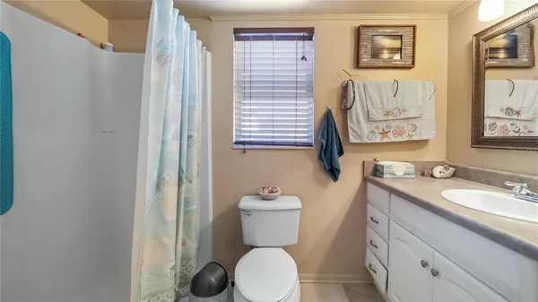 a bathroom with a granite countertop toilet sink and mirror