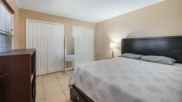 a bedroom with a bed and painting on the wall