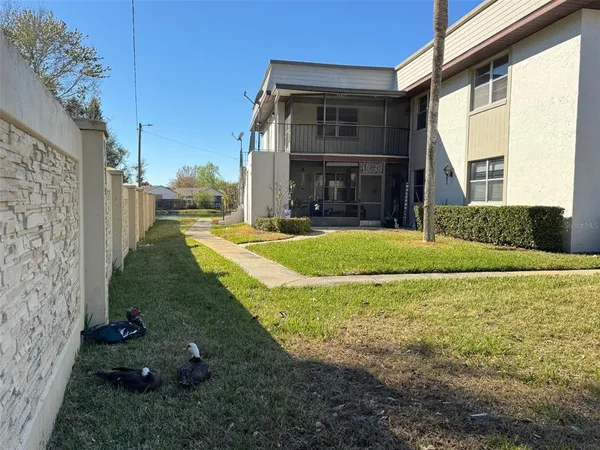 a view of a house with backyard and sitting area
