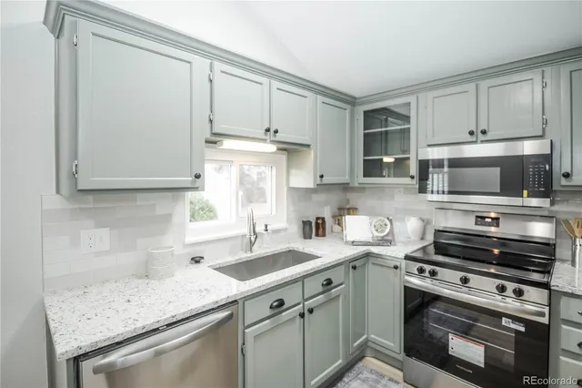 a kitchen with stainless steel appliances granite countertop a sink stove oven and white cabinets