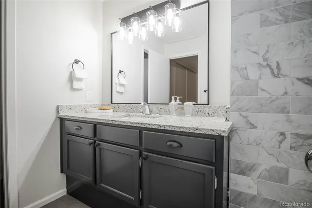 a bathroom with a granite countertop sink and a mirror