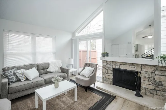 a living room with furniture a large window and a fireplace