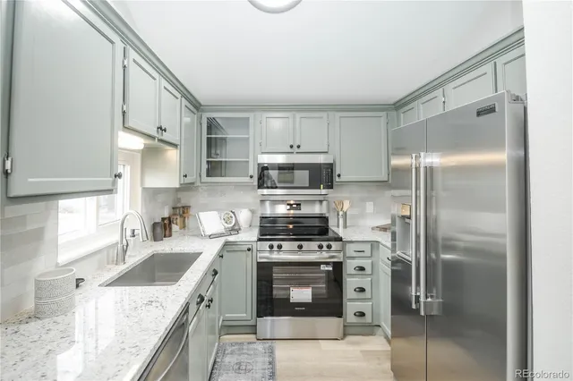 a kitchen with a stove a refrigerator and a sink