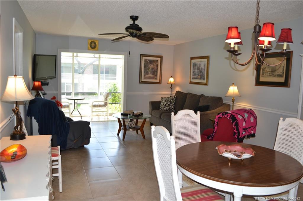 1969 Southwest Palm City Road, Unit G Stuart, FL 34994 - Photo 18 of 76 a living room with furniture and a chandelier