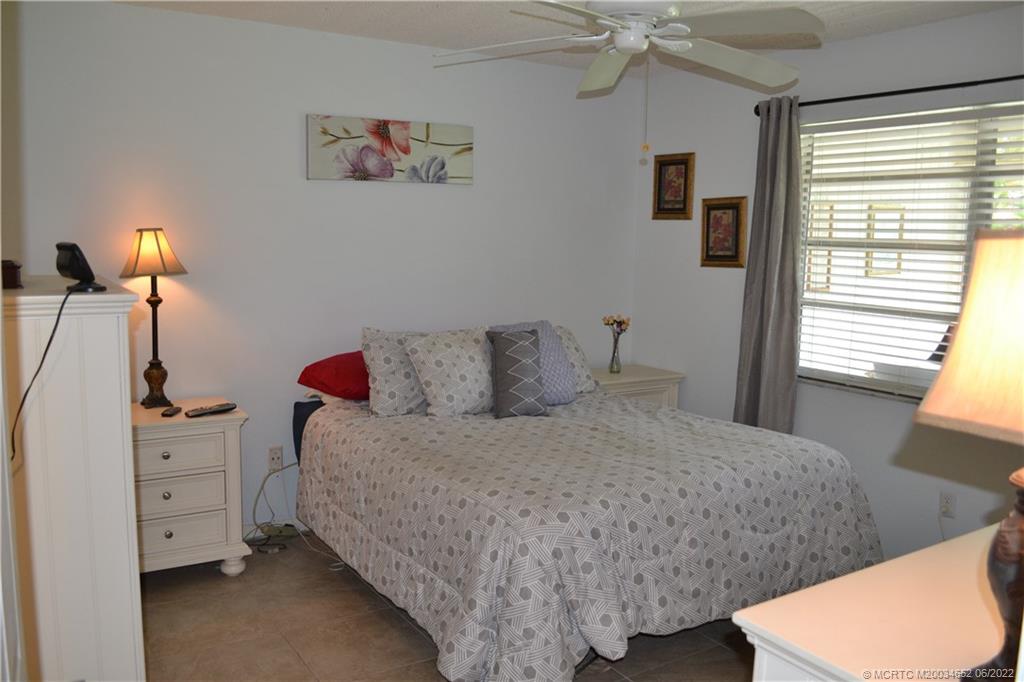 1969 Southwest Palm City Road, Unit G Stuart, FL 34994 - Photo 23 of 76 a bedroom with a bed and a dresser