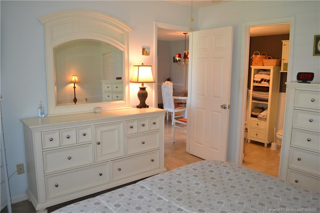 1969 Southwest Palm City Road, Unit G Stuart, FL 34994 - Photo 26 of 76 a bedroom with a bed and a dresser in it