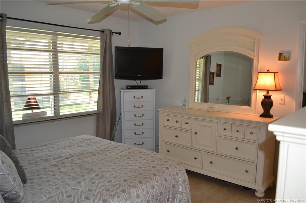 1969 Southwest Palm City Road, Unit G Stuart, FL 34994 - Photo 27 of 76 a bedroom with a bed and a flat tv screen on dresser