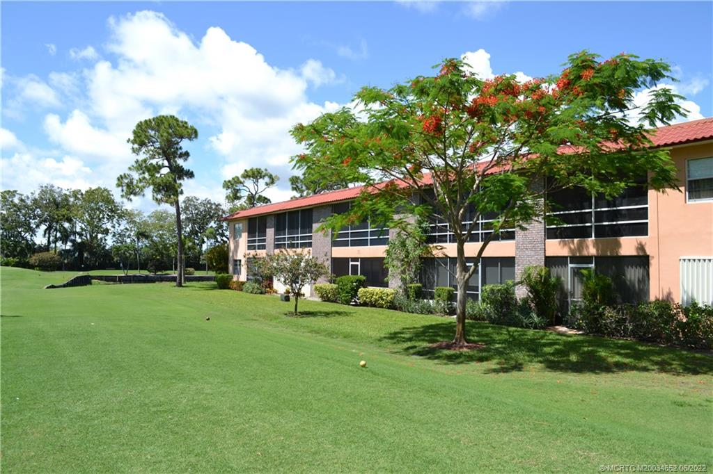 1969 Southwest Palm City Road, Unit G Stuart, FL 34994 - Photo 3 of 76 a front view of a house with a yard and trees