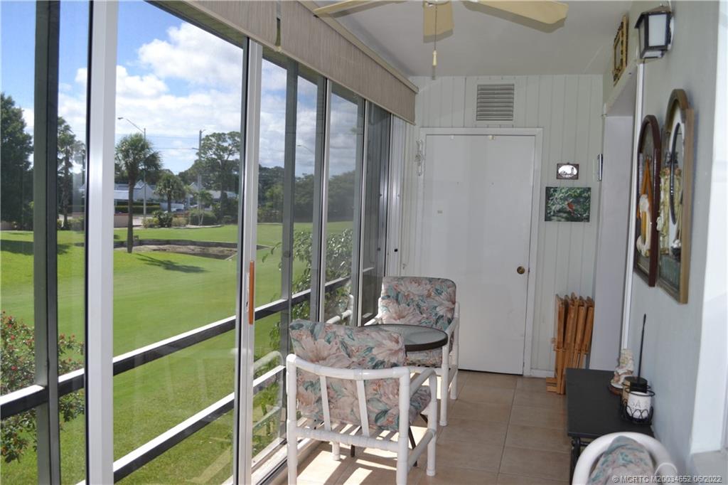 1969 Southwest Palm City Road, Unit G Stuart, FL 34994 - Photo 41 of 76 a room with furniture a flat screen tv and a floor to ceiling window