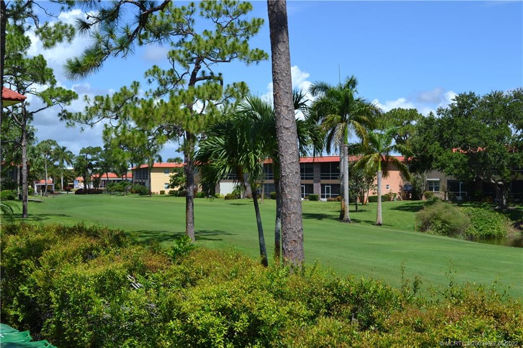 1969 Southwest Palm City Road, Unit G Stuart, FL 34994 - Photo 46 of 76 a view of a house with a big yard and palm trees