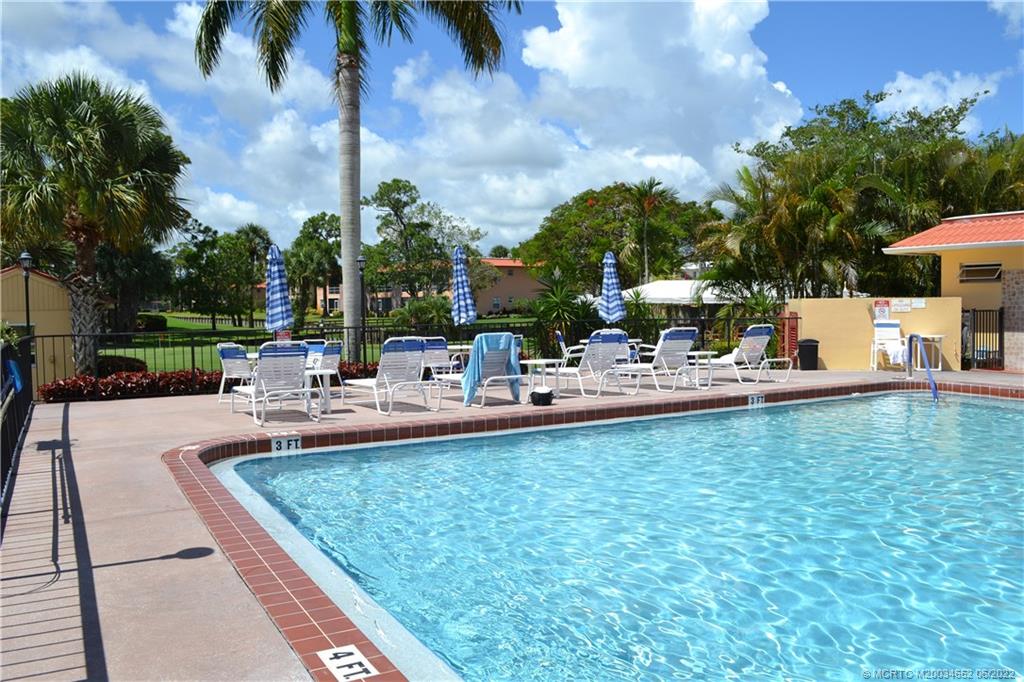 1969 Southwest Palm City Road, Unit G Stuart, FL 34994 - Photo 67 of 76 a view of a swimming pool with chairs and a tables