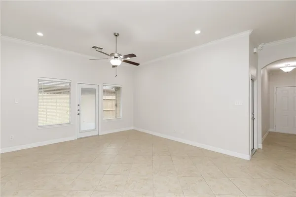 an empty room with fan and windows