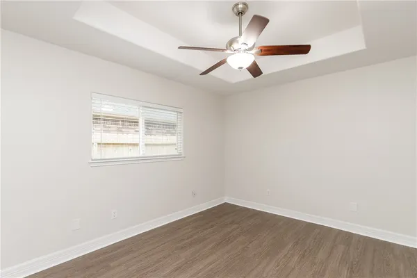 an empty room with wooden floor closet and ceiling fan