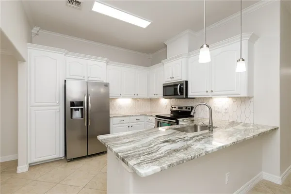a kitchen with stainless steel appliances granite countertop a refrigerator a stove top oven a sink and dishwasher