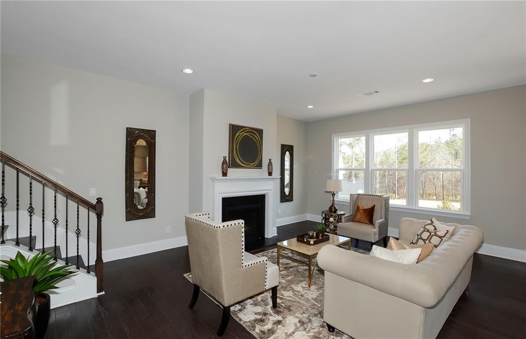 4316 Azalea Rdg Way Hoschton, GA 30548 - Photo 11 of 36 a living room with furniture a fireplace and a potted plant