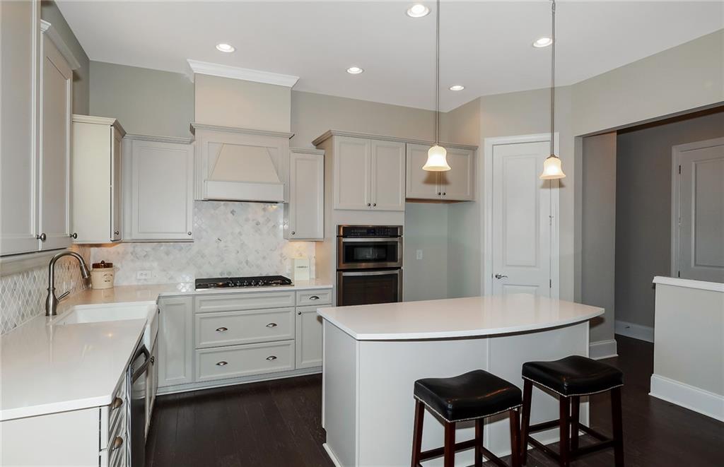4316 Azalea Rdg Way Hoschton, GA 30548 - Photo 15 of 36 a kitchen with a table chairs microwave and cabinets