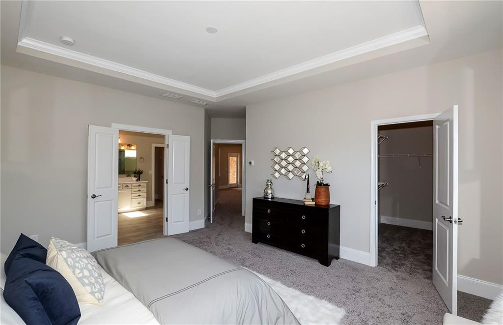 4316 Azalea Rdg Way Hoschton, GA 30548 - Photo 22 of 36 a bedroom with a bed and a chandelier