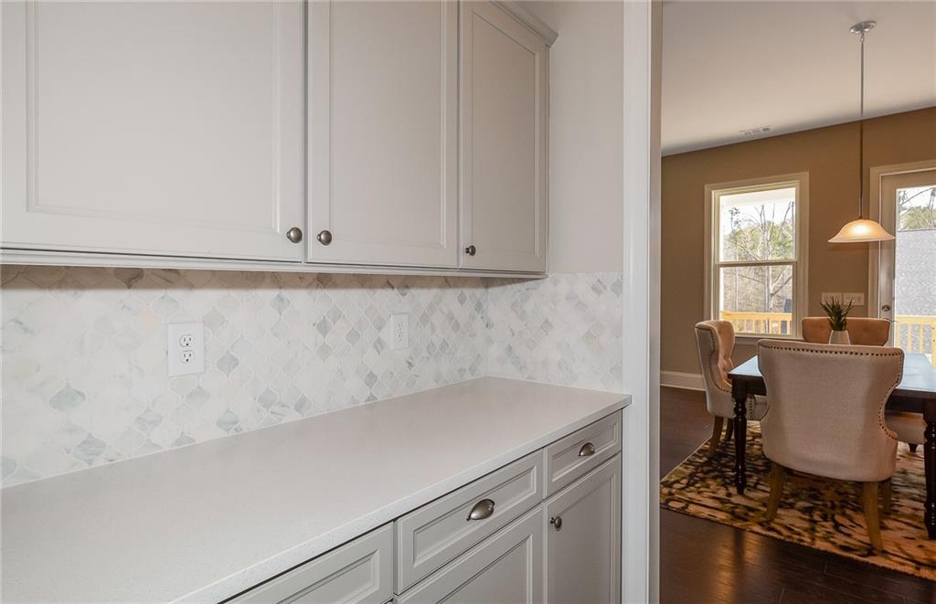 4316 Azalea Rdg Way Hoschton, GA 30548 - Photo 9 of 36 a room with a table chairs and a stove top oven