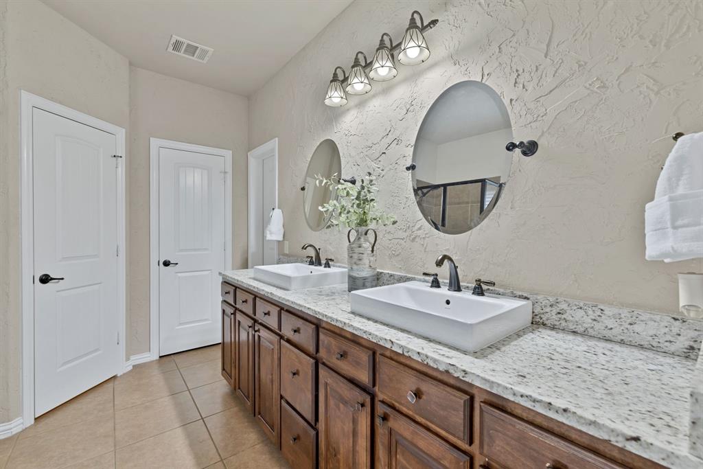 1701 Meadow Ranch Road McKinney, TX 75071 - Photo 19 of 40 a spacious bathroom with double vanity sinks and a mirror