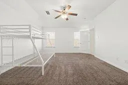 a view of a livingroom with a ceiling fan and window