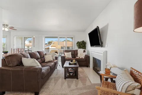 a living room with furniture a fireplace and a flat screen tv
