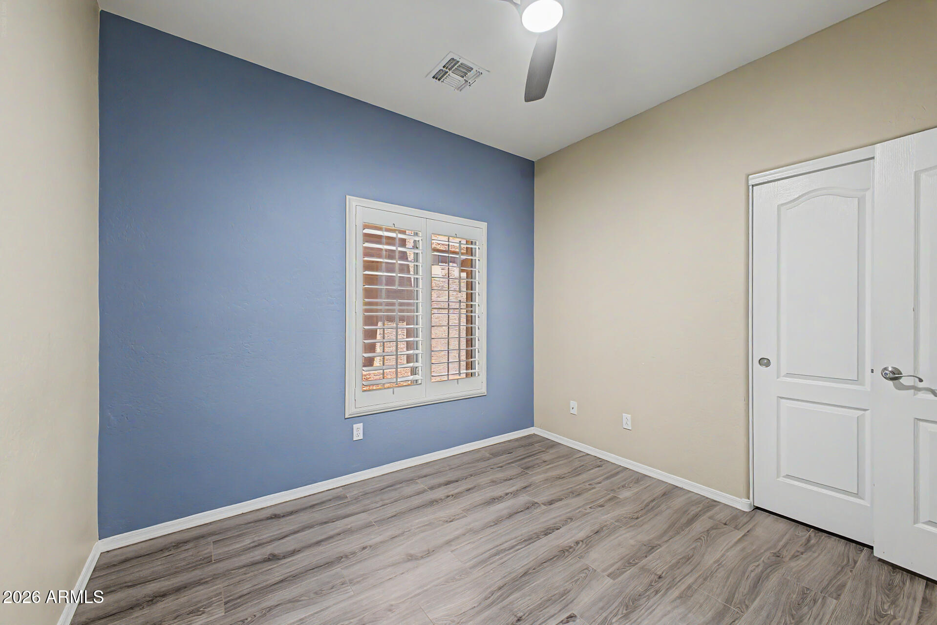 2600 East Springfield Place, Unit 109 Chandler, AZ 85286 - Photo 21 of 38 an empty room with wooden floor chandelier fan and windows