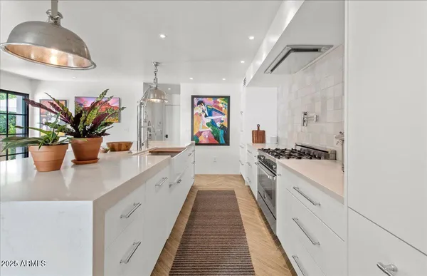a large kitchen with stainless steel appliances granite countertop a lot of counter space