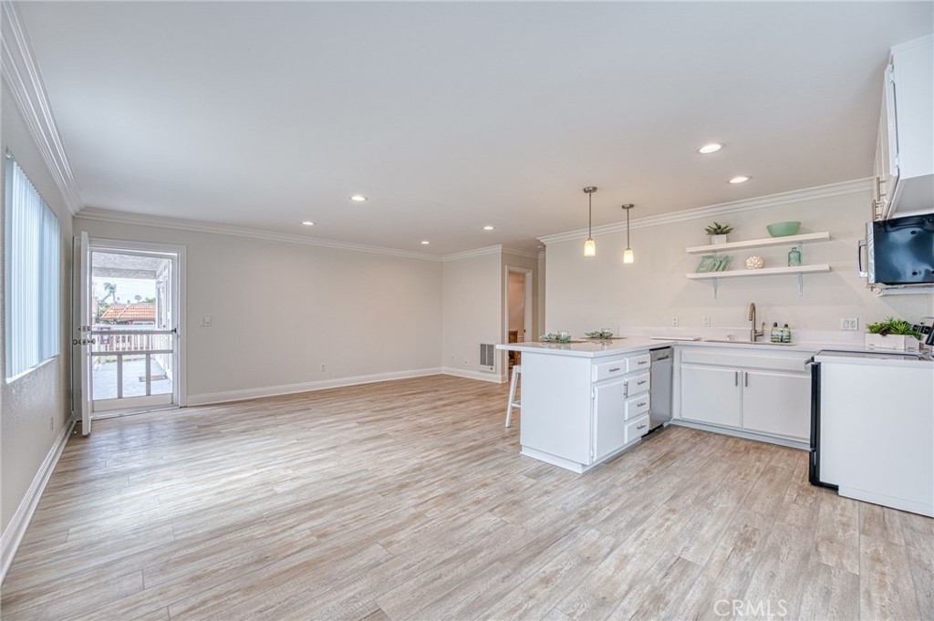33782 Malaga Drive, Unit C Dana Point, CA 92629 - Photo 2 of 11 a large kitchen with a wooden floor and white stainless steel appliances