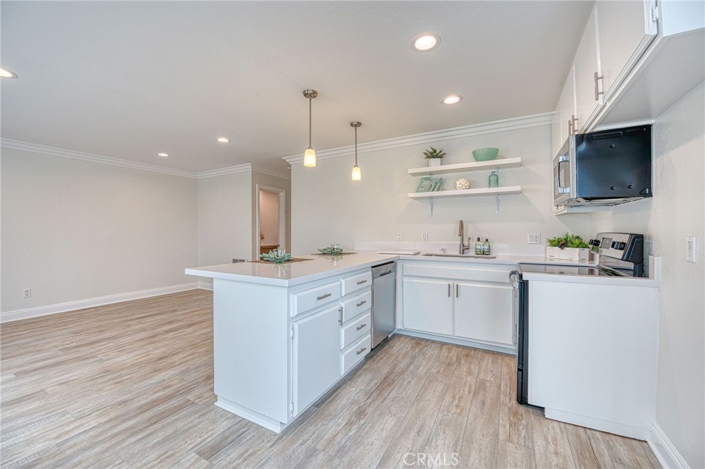 33782 Malaga Drive, Unit C Dana Point, CA 92629 - Photo 3 of 11 a kitchen with white cabinets stainless steel appliances a sink and a stove