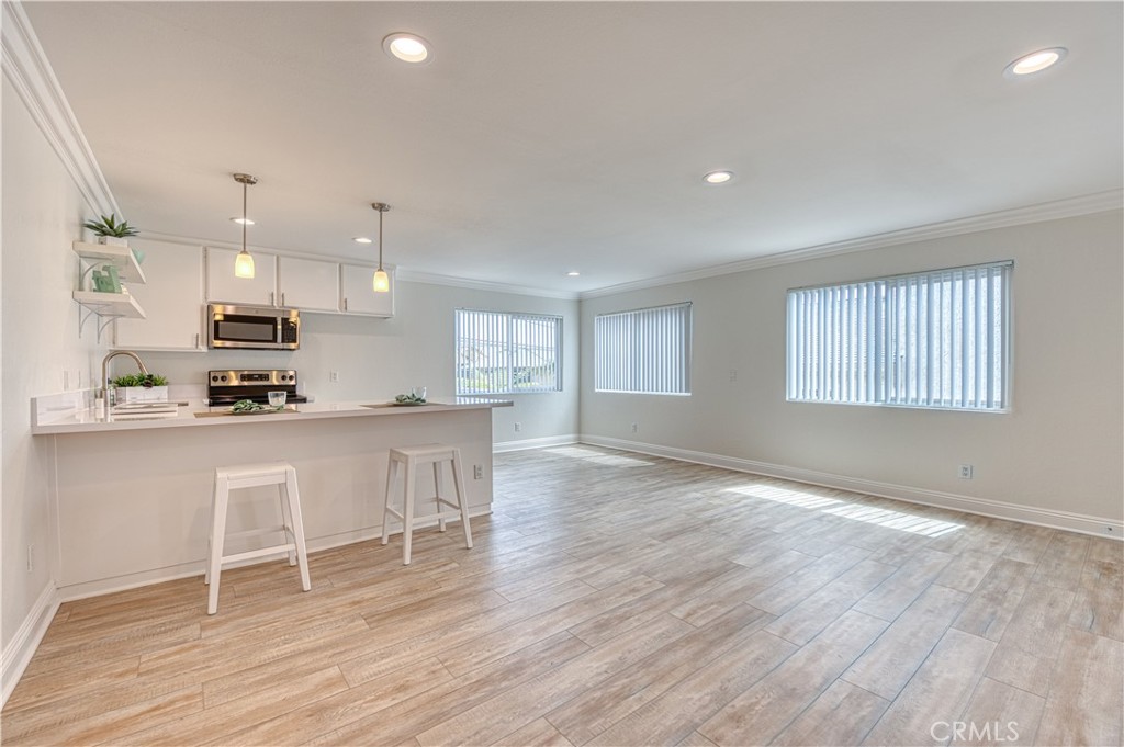 33782 Malaga Drive, Unit C Dana Point, CA 92629 - Photo 4 of 11 a open kitchen with white cabinets and wooden floor