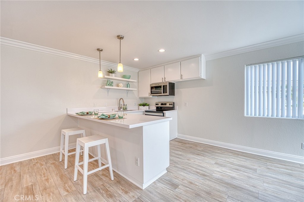 33782 Malaga Drive, Unit C Dana Point, CA 92629 - Photo 5 of 11 a kitchen with granite countertop white cabinets and white appliances